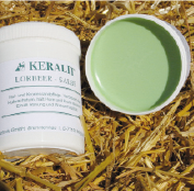 KERALIT Leberbalsam KERALIT Leberbalsam in einem weißen Behälter, geöffnet mit grünem Inhalt, auf Stroh platziert.